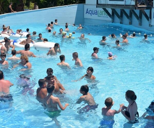 pool crowded with adults and kids