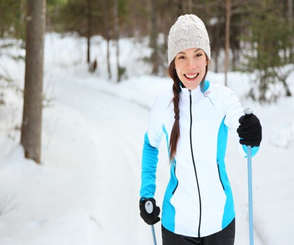 woman cross country skiing smiling at camera