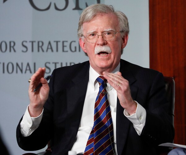 former national security adviser john bolton sits and gestures while speaking at a convention