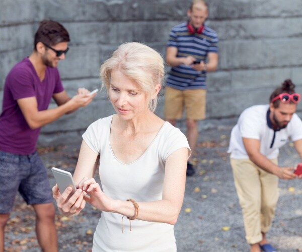 people outside intent on looking at their cell phones