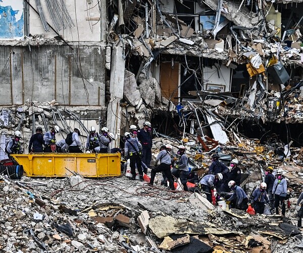 search and rescue look for survivors in building collapse rubble