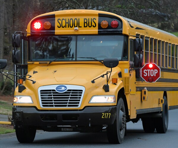 a school bus is stopped to pick up kids