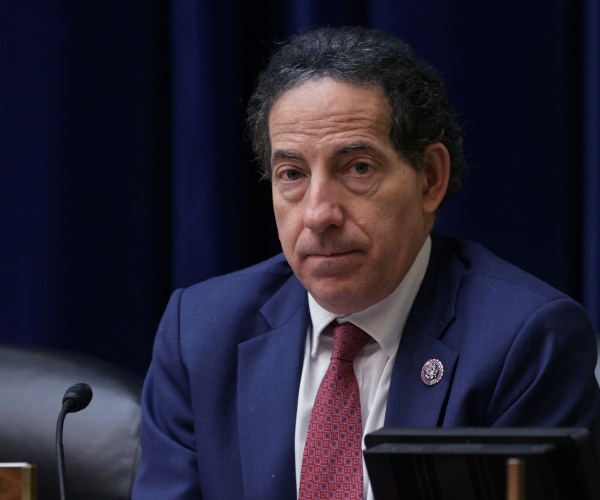 jamie raskin seated behind microphone