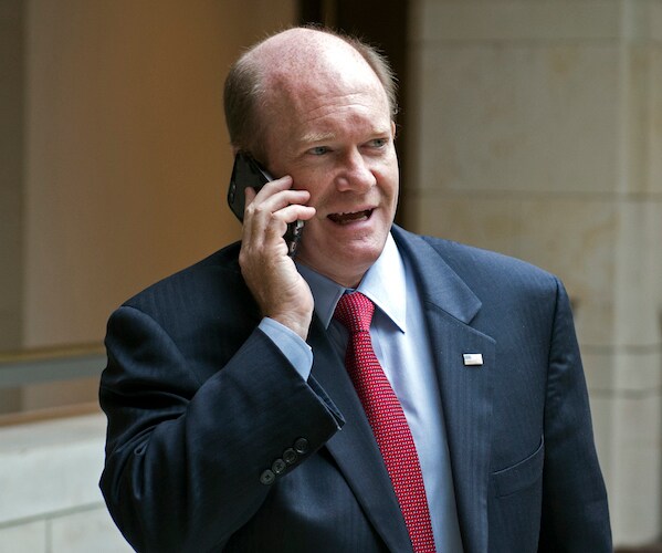 chris coons speaks on a cell phone on capitol hill