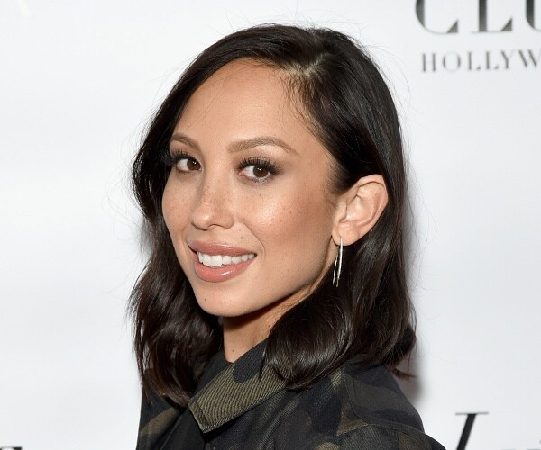 cheryl burke stands on red carpet