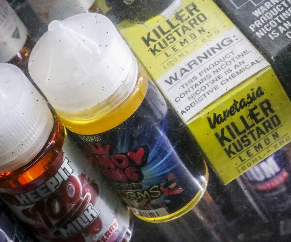 flavored vaping solutions are shown in a window display at a vape and smoke shop in New York.