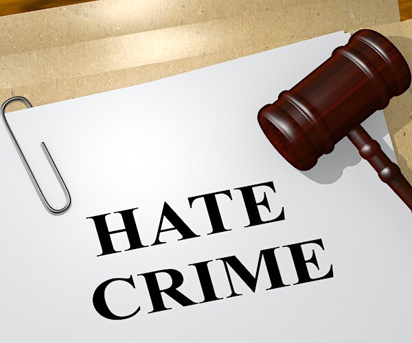 a gavel with a paper that reads hate crime