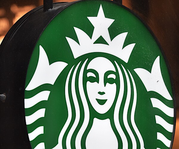 a starbucks logo on a sign outside of a coffee shop