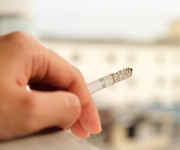 close up of a burning cigarette in hand