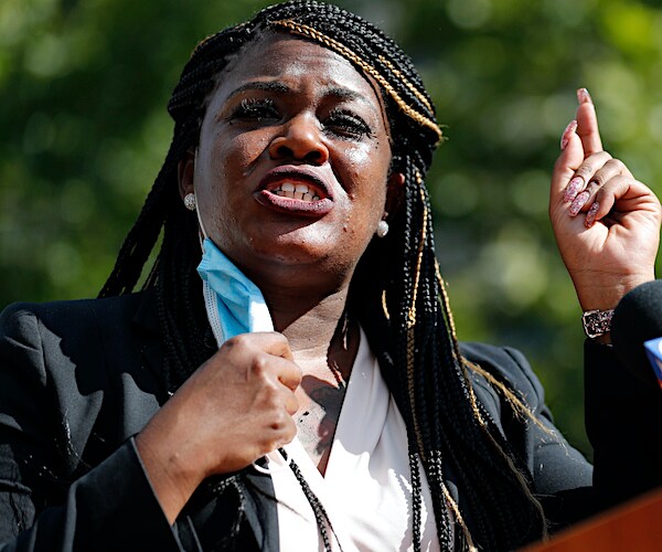 cori bush exults during a campaign rally speech