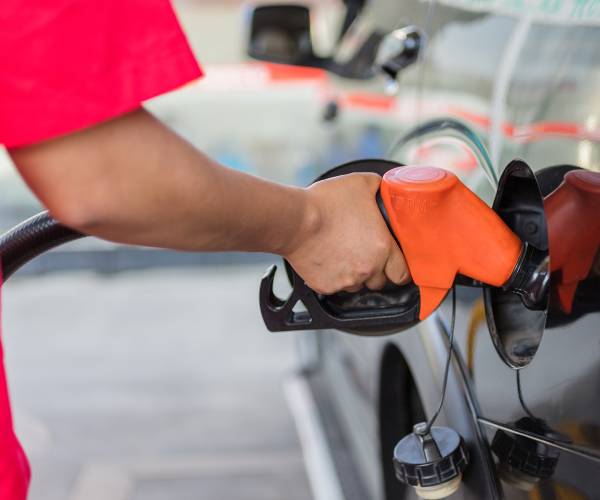 a person pumping gasoline into a car