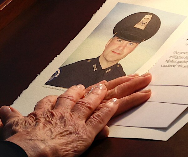 a photograph of the late capitol police officer brian sicknick on a memorial paper in the capitol rotunda