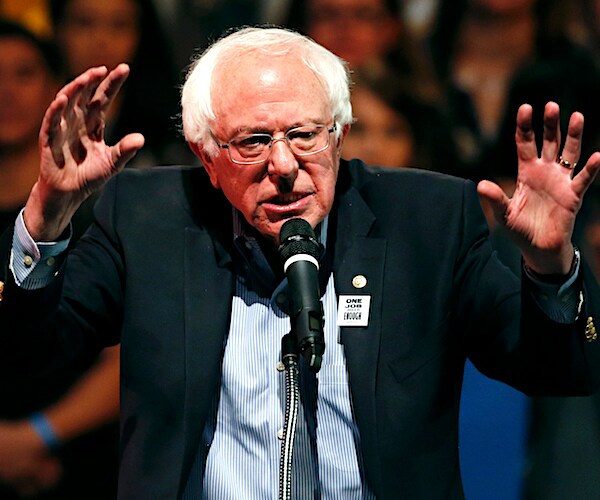 bernie sanders holds up both hands like a bear