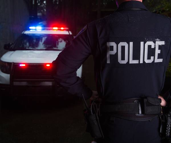 staged photo of a police officer and police car