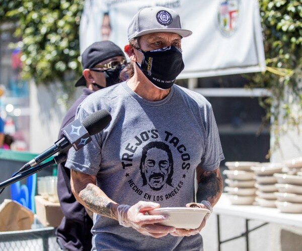 trejo in a gray trejo's tacos t shirt holding a bowl of food