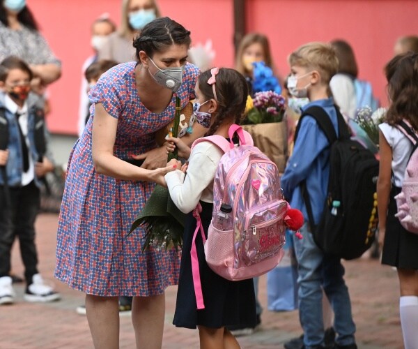 children wearing face masks go to school