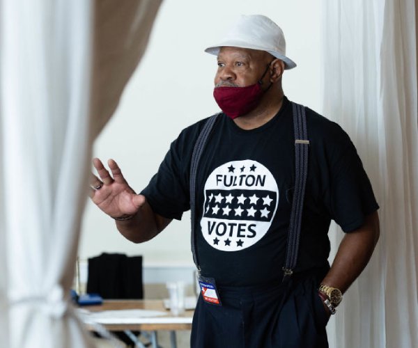 poll worker kelvin ellis helps voters in atlanta