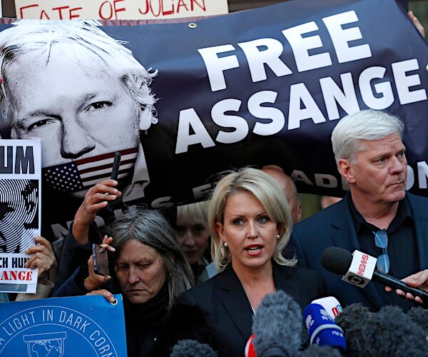 wikileaks editors and lawyers stand during a news conference with a free julian assange banner in the background