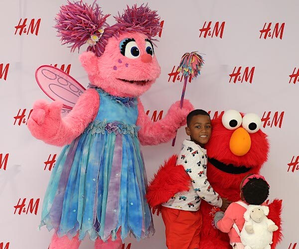 gabby and elmo gets hugs from kids at a red carpet event