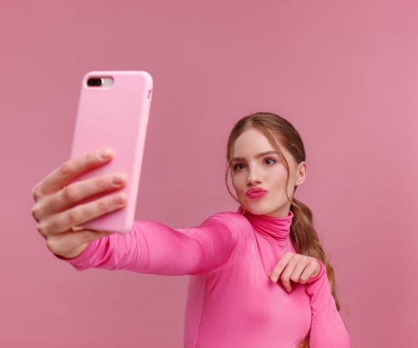 woman in all pink taking pictures of herself