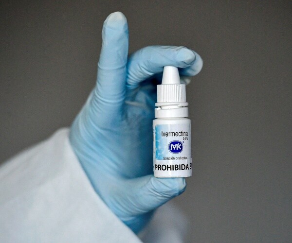 A health worker shows a bottle of Ivermectin.