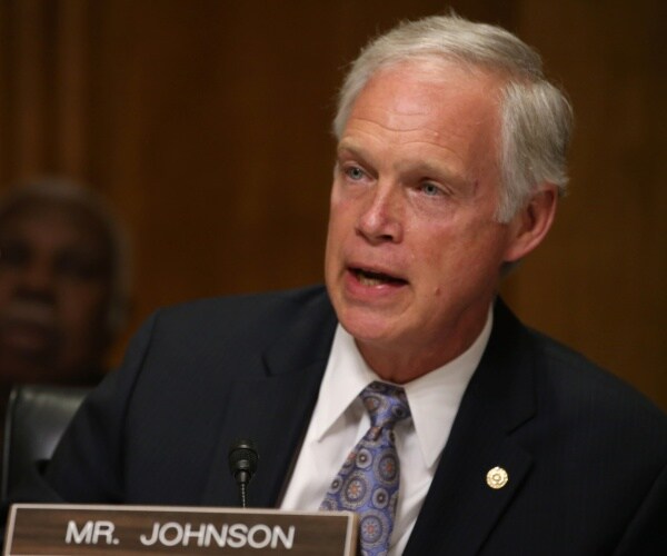 ron johnson wearing a patterned purple tie and suit speaking during a hearing