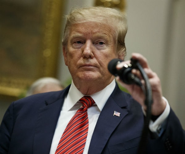 president donald trump adjusts a mic before delivering remarks to the media