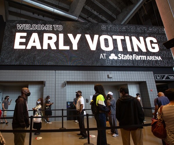 voters line up under an early voting sign 