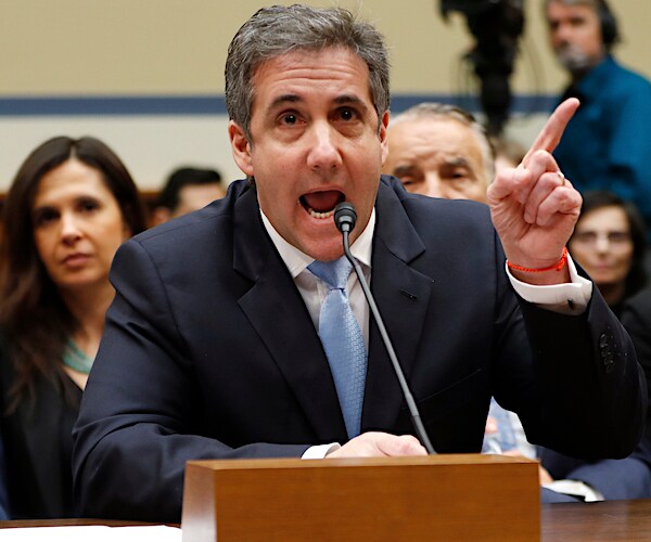 michael cohen exults and points with his right index finger up high during a house oversight hearing