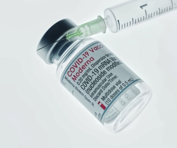 a vial labeled Moderna COVID-19 vaccine and a syringe