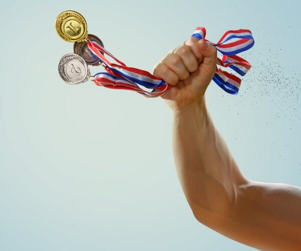 a hand holding three medals -- gold, silver and bronze