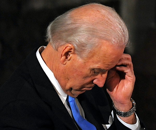 joe biden bows his head during a news conference