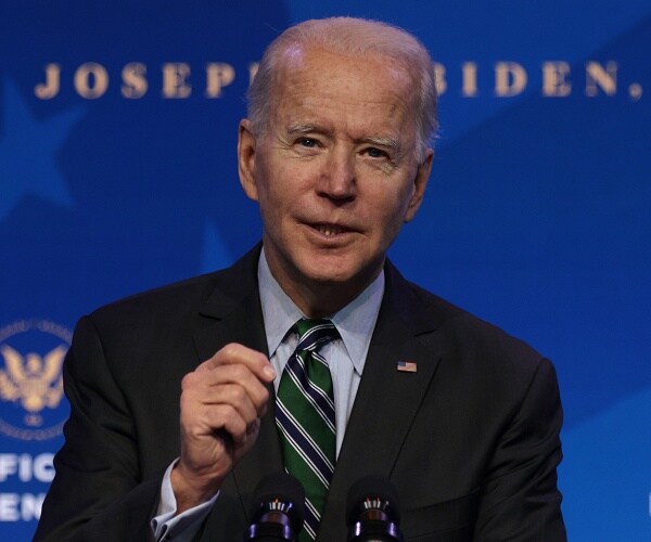 joe biden speaks into microphone behind podium