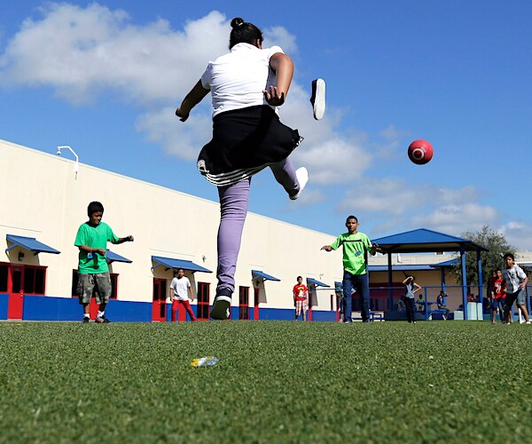 kids play kickball at a migrant children detention center