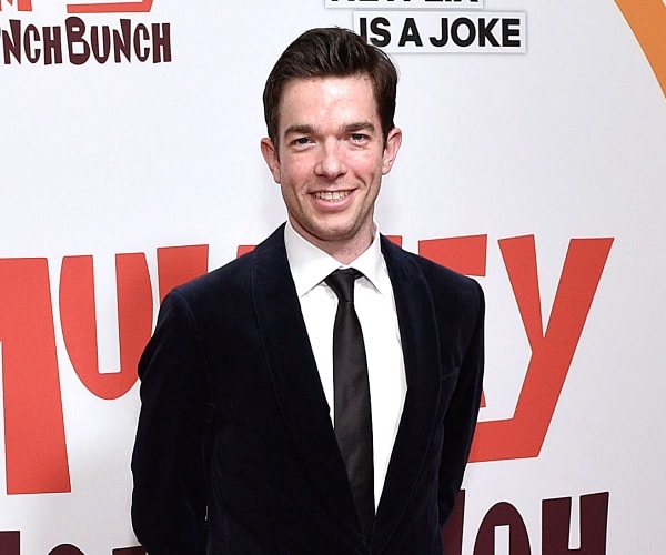 john mulaney stands on red carpet