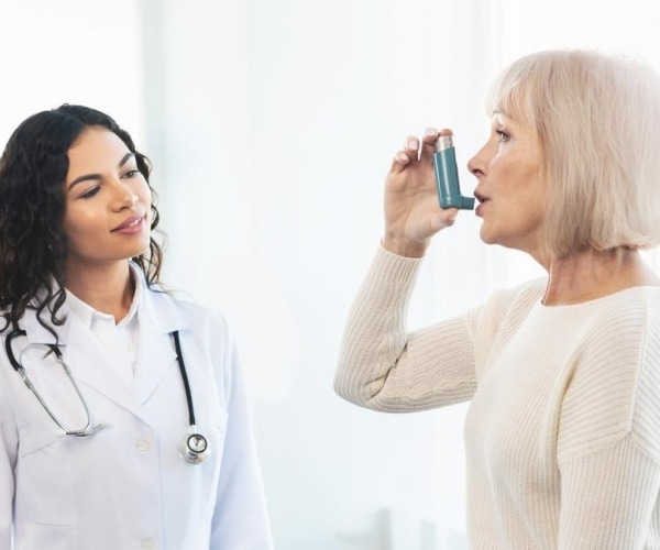 doctor with woman patient using an inhaler