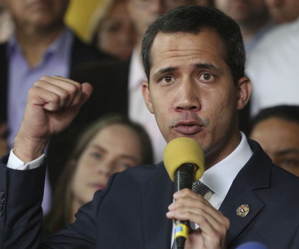 juan guaidó, venezuela’s opposition leader, speaks into a microphone as he clinches his right hand into a fist