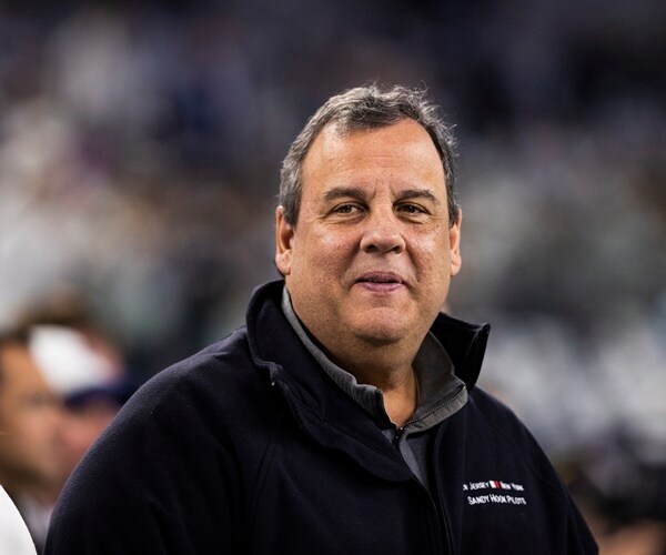 chris christie stands on a football field