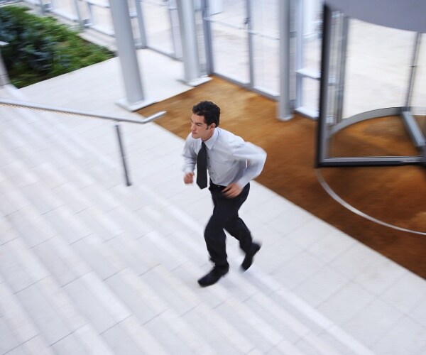 businessman in suit running upstairs