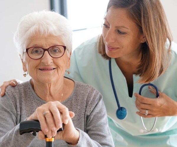 Healthcare worker helping a woman with dementia