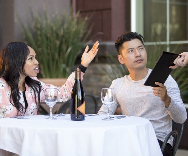 man and woman at a table in restaurant complaining to their waitress