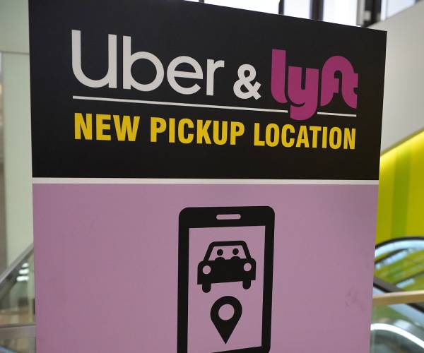 a sign advertising uber and lyft pickup point