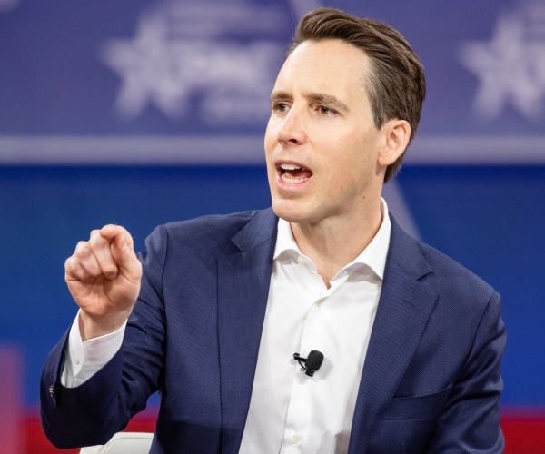 hawley in a navy blue suit and white shirt speaking at cpac