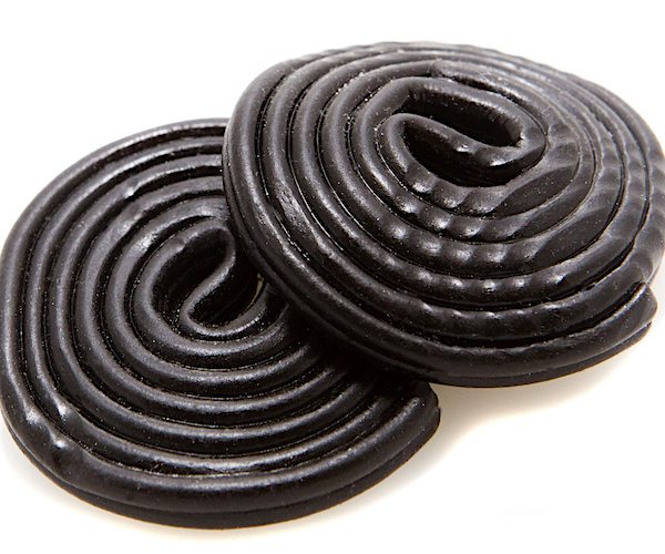 two rolls of black licorice are piled on a white table