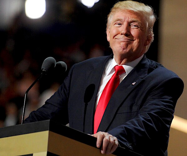 president donald trump smirks at the podium during a campaign speech