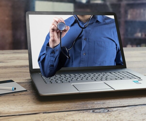 a patient doing telehealth on a laptop with a doctor