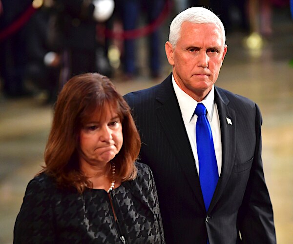 Former second lady Karen Pence and former VP Mike Pence walk with frowns