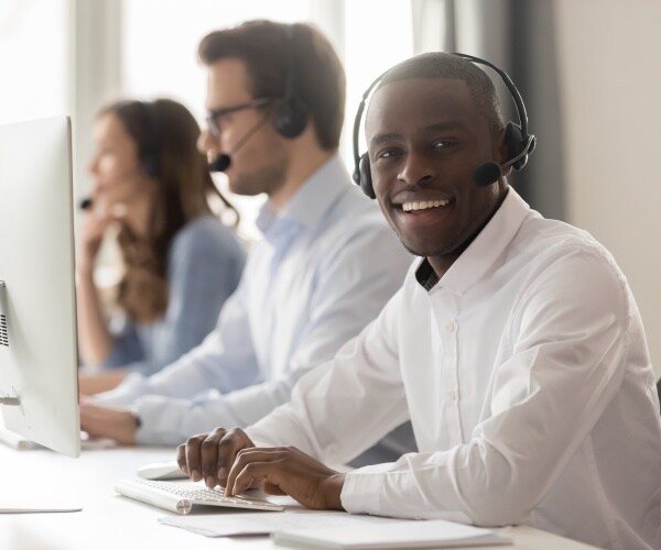 workers at call center smiling at camera