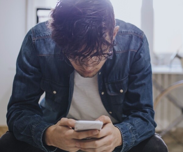 teen boy betting on his smartphone