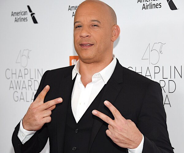 actor vin diesel flashes up two fingers from each hand to signal peace on the red carpet